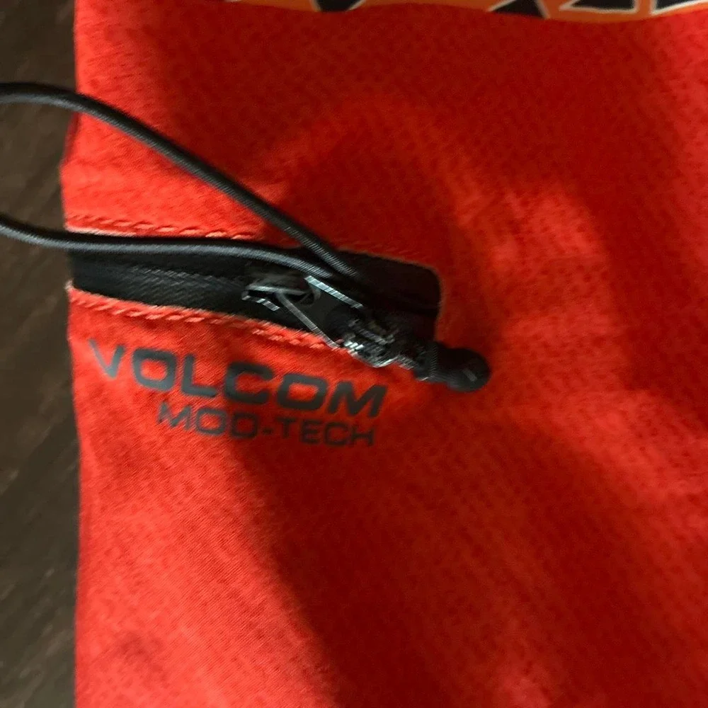 Preowned 2015 Volcom board shorts with orange, white, and black abstract